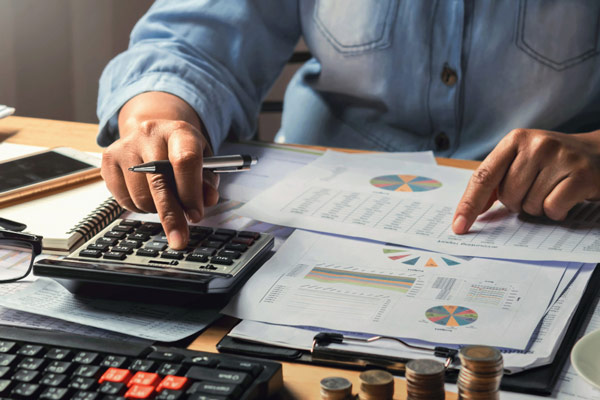 A person using a calculator to calculate business costs.