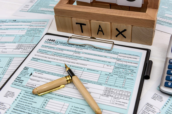 Tax forms and calculator on desk: essential tools for filing taxes and calculating accurate amounts.